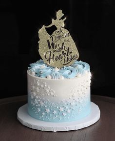 a blue and white cake with a gold topper that says, one day at a wish your heart maker