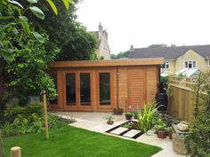 a backyard with a wooden shed and green grass