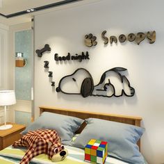 there is a bed with a teddy bear on it and a sign that says snoopy