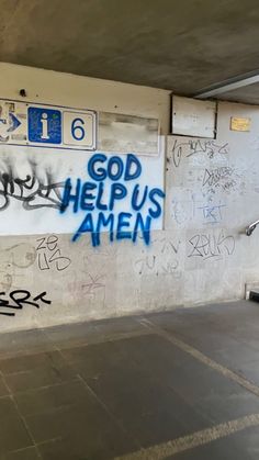 graffiti is spray painted on the wall in an empty parking garage