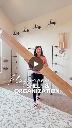 a woman is holding a large wooden object in her hand while standing on the floor