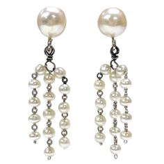 14 Karat White Gold Cultured Pearl Dangle Earrings. One pair of cultured pearl earrings. Each earring is comprised of one 8.0 to 8.5mm diameter close to spherical cultured pearl peg set onto a pad with three strands of five pearls each dangling from a jump-ring below. Each strand is joined by white gold wire loops between the approximately 3.0 to 3.1mm diameter pearl. The earrings have a post and friction backs for pierced ears. The earrings weigh 4.9 grams overall. The two larger pearls are cre Pearl Dangle Earrings, Pearl Earrings Dangle, Toned Body, Light Cream, Gold Wire, Dream Jewelry, Earrings Dangle, Cultured Pearls, Jump Rings