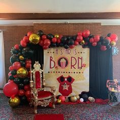 a stage set up for a birthday party with balloons and decorations on the floor,