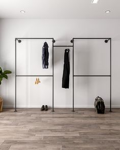 an empty room with clothes hanging on the wall and shoes sitting on the floor next to it