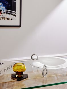 a glass table with a bowl on it and a metal hook in the middle that is holding an object