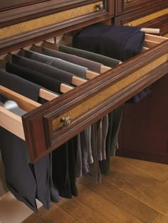 an open drawer in a closet filled with clothes