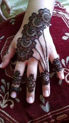 a woman's hand with henna tattoos on it