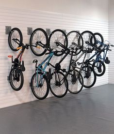 several bikes are hanging on the wall in a bike storage area with two racks holding bicycles