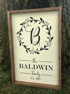 a sign that says the baldwin family on it in front of some grass and trees