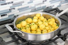 a pan filled with potatoes sitting on top of a stove