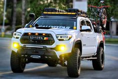 a white toyota truck driving down a street