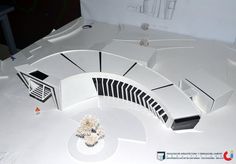 a model of a futuristic building with white walls and black trim on the top part