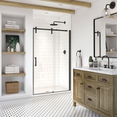 a bathroom with white walls and black accents, including a walk in shower next to a double sink