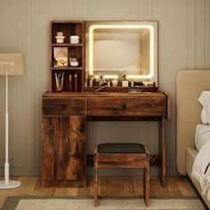 a wooden desk with a mirror, stool and lamp in a small room next to a bed