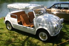 an old fashioned car parked next to a lake