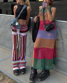 two women standing next to each other with umbrellas on their heads and one holding a cell phone