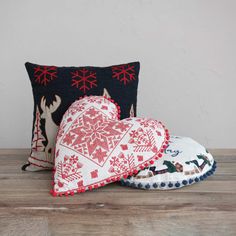 two decorative heart shaped pillows sitting on top of a wooden table next to a pillow