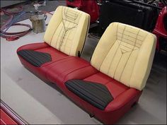 two red and white seats sitting next to each other in front of a black car