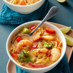 two bowls of soup with shrimp, broccoli and noodles