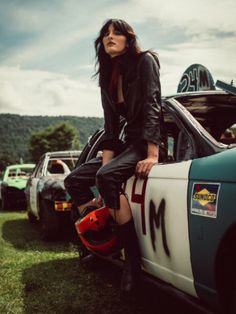 a woman sitting on the hood of a car