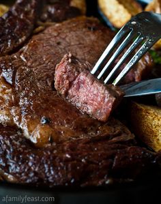 a fork is stuck into some steak and potatoes