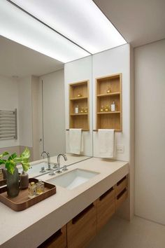 a bathroom with two sinks and wooden cabinets