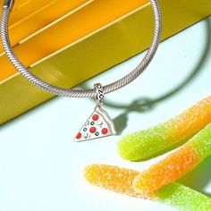 Show off your love for pizza, and food for all occasions with this Delicious Pizza Slice Pendant Dangle Charm. Made in 925 sterling silver, this charm features red enamels and green CZ stones. Wear the Italian-inspired dangle on your bracelet to show the love, or gift it as a treat to someone you know with a love for pizza. Trendy Sterling Silver Charms Jewelry, Trendy Sterling Silver Jewelry With Charms, Trendy Charms With Dangling Details As Gift, Stainless Steel Dangle Jewelry With Charms, Stainless Steel Dangling Charms Jewelry, Trendy Pendant Charm As Gift, Trendy Pendant Charms As Gift, Trendy Silver Necklaces With Removable Charms, Trendy Pendant Charms For Gift