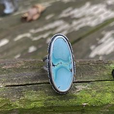 "With A Head Full Of Snow" Soft cornflower blue with a gorgeous pattern, this Gobi Desert Lavender Turquoise cabochon is set in fine and sterling silver, with a cutout sterling border. Oxidized and tumbled for a satin finish. Sterling silver split shank band. The stone setting measures approximately 34mm tall by 16mm wide. Size 6.5 US Southwestern Style Untreated Blue Turquoise Ring, Unique Blue Turquoise Ring With Inlay, Southwestern Blue Chrysocolla Rings, Artisan Turquoise Oval Cabochon Ring, Blue Oval Rings With Inlay, Blue Turquoise Ring With Large Stone In Sterling Silver, Blue Sterling Silver Ring With Patina, Blue Sterling Silver Rings With Patina, Southwestern Blue Turquoise Ring With Patina