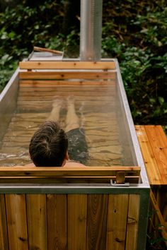 a man in a hot tub with his back turned to the camera and head above water