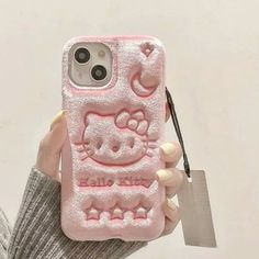 a person holding a pink hello kitty phone case