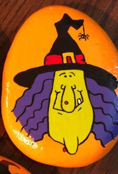 a painted rock with an image of a cartoon character in a witches hat on it