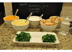 a counter topped with bowls filled with different types of dips and cheese covered tortillas