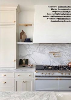 a kitchen with white cabinets and marble counter tops, gold pulls on the oven hood