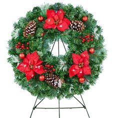 a christmas wreath with poinsettis and pine cones on a tripod stand