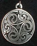 a silver pendant with an intricate design on it