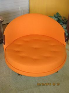 an orange couch sitting in the middle of a room