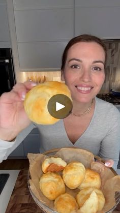 a woman holding up a bagel in front of her face and smiling at the camera