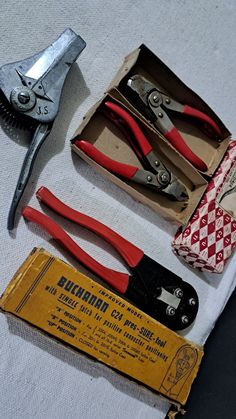 some tools are laying out on the table next to an empty box and other items