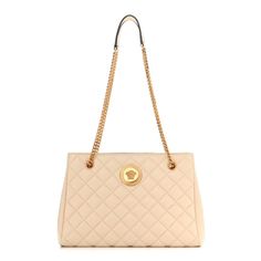 This luxurious Versace shoulder bag is crafted of quilted leather in beige. The creamy beige neutral leather allows the iconic a gold La Medusa logo plaque to shine. Opulence and detail are seen in every area of this quilted leather tote bag. The spacious black fabric interior features a zipper pocket perfect for storing daily essentials. The overall look is finished with two chain shoulder straps with leather pads at the top.  This Versace La Medusa handbag from Versace will be a classic additi Beige Shoulder Bag With Gold-tone Logo For Everyday Use, Elegant Quilted Shoulder Bag For Shopping, Beige Quilted Evening Bag, Beige Quilted Evening Shoulder Bag, Elegant Quilted Beige Bag, Beige Quilted Shoulder Bag For Shopping, Chic Cream Quilted Shoulder Bag, Beige Evening Bag With Gold-tone Logo Plaque, Everyday Beige Shoulder Bag With Gold-tone Logo