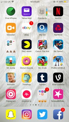 an iphone screen with many different icons on the phone and in front of it is a white furry animal's head