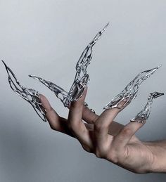 a person's hand holding out their fingers with water dripping from them on a blue background