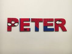 the word peter written in cut out letters on a white wall with red and blue accents