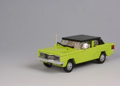 a green toy truck with a solar panel on the roof and lights in the back