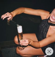 a woman sitting down holding a glass of beer