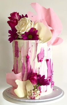 a white and pink cake with flowers on top