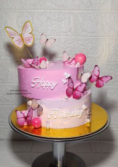 a pink birthday cake with butterflies on it