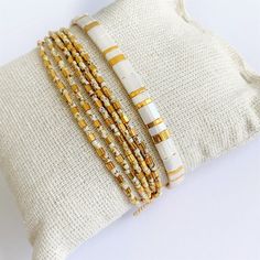 Beautiful set of two bracelets, a beaded strech wrap bracelet with lots of gold plated beads that gives the braclet a beautiful sparkle combined with an adjustable tila bracelet on silk cord. M A T E R I A L * Seed beads from Miyuki (high quality seed beads from Japan) gold plated (24 kt) and off white with brown/beige pattern * Very strong elastic * Silk cord * Tila beads, off white & gold ( 24 kt gold plated) * Gold plated sliding bead ( with rubber inside so the bracelet is adjustable) S Woven Bracelet Diy, Stretch Beaded Bracelets Diy, Tila Bracelets, Bracelets Dainty, Jewelry Stacking, Tila Beads, Loom Bracelet, Beige Pattern, Woven Bracelet