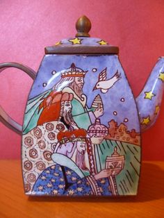 a ceramic teapot with a painting on it