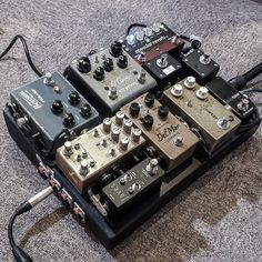 an array of different pedals sitting on top of each other in a room with carpeted flooring