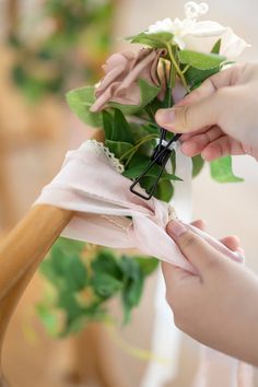 a person is tying a flower to a piece of cloth